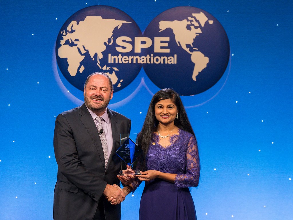 Yoshi Pradhan receiving an award on the SPE International stage