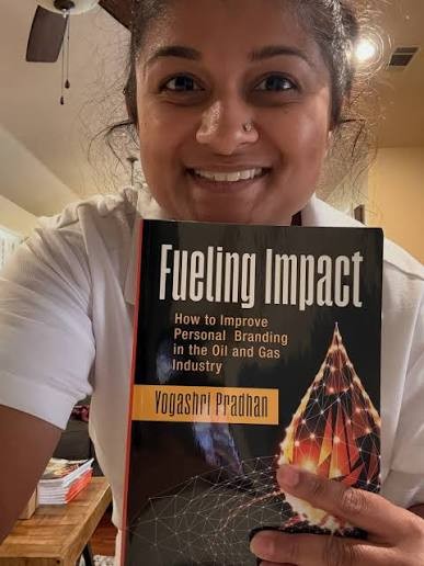 Yoshi Pradhan holding a copy of Fueling Impact